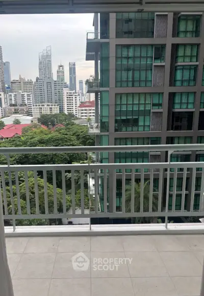 Spacious balcony with stunning cityscape view in modern high-rise building.