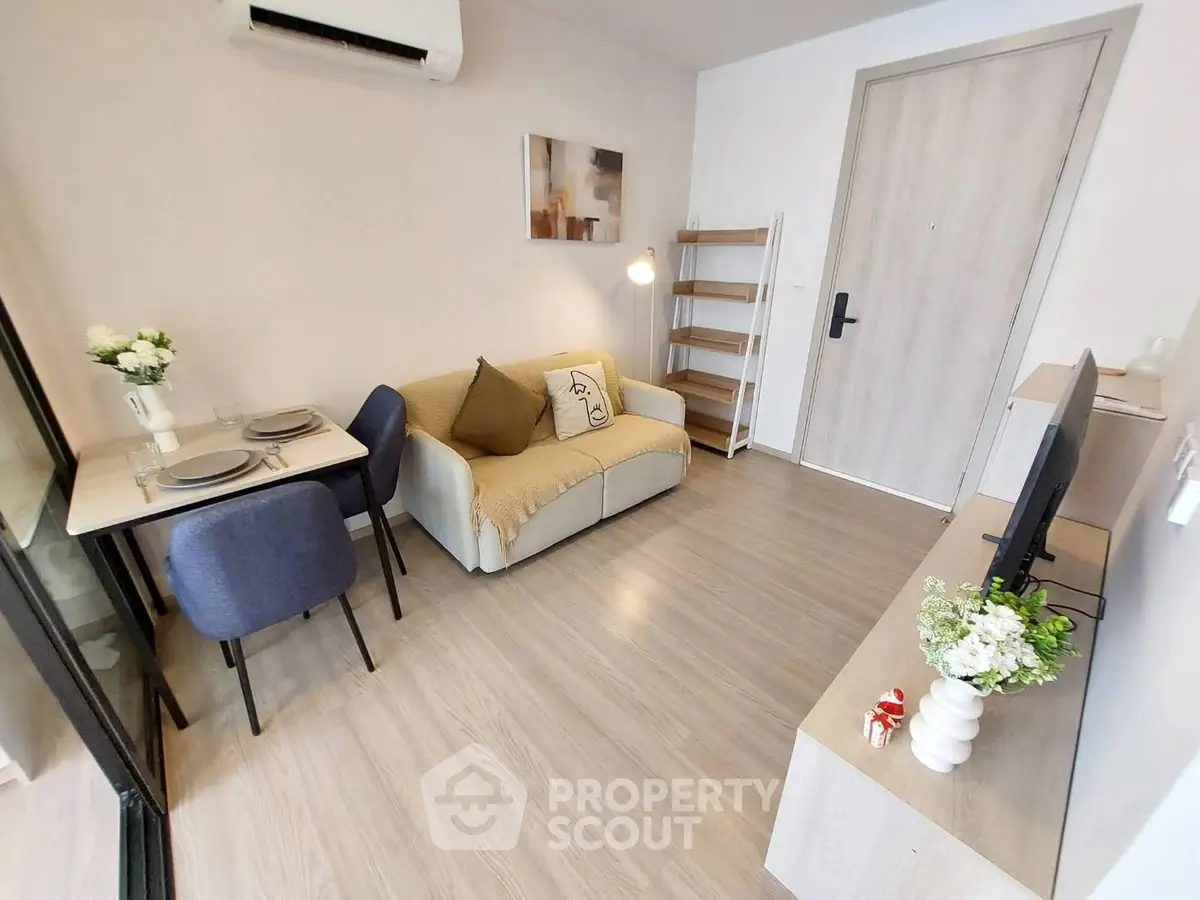 Cozy modern living room with stylish decor and dining area in compact apartment.