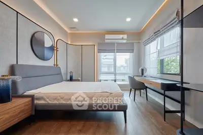 Modern bedroom with stylish decor and large windows offering natural light.