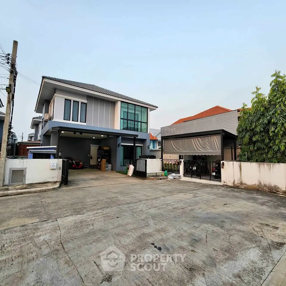 Modern two-story house with spacious driveway and garage in a suburban neighborhood.