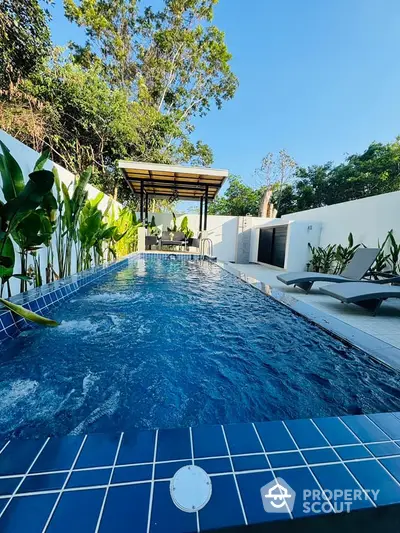 Luxurious private pool with lush greenery and modern lounge area