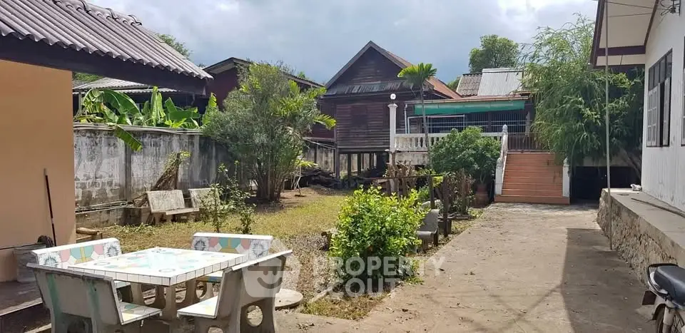Charming rustic backyard with traditional wooden house and outdoor seating area.