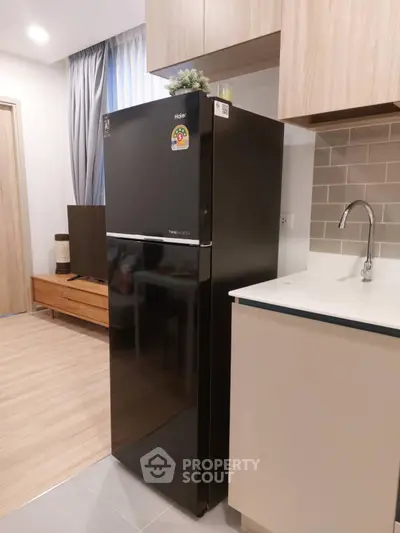 Modern kitchen with sleek black fridge and stylish cabinetry