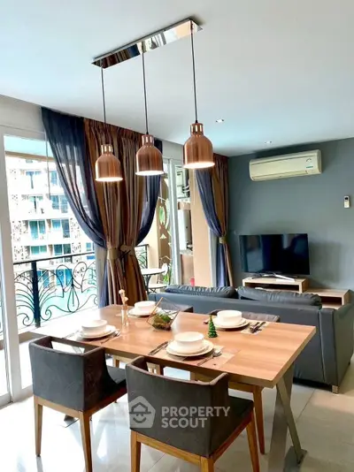 Modern living room with dining area, stylish lighting, and balcony view in a contemporary apartment.