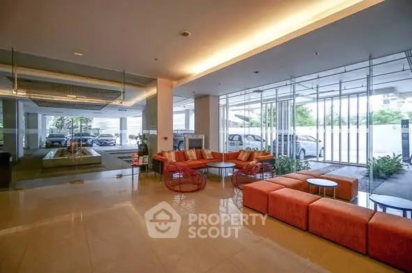 Modern lobby with stylish seating and glass walls offering a view of the exterior.