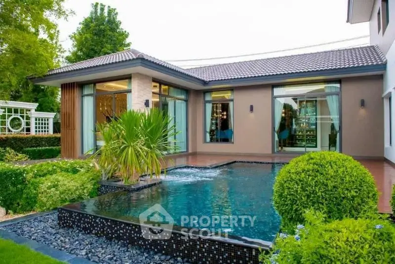 Luxurious modern home with stunning pool and lush garden, perfect for serene living.