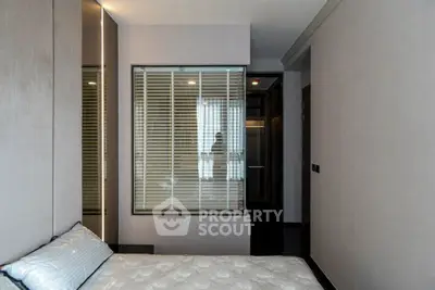 Modern bedroom with sleek design and large window for natural light.