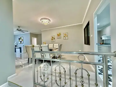Elegant dining area with modern decor and chandelier in a spacious open-plan layout.
