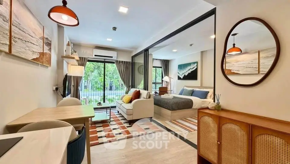 Modern open-plan living room and bedroom with stylish decor and large windows.