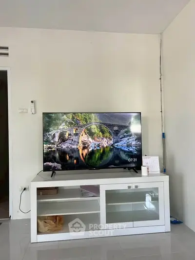 Modern living room with sleek TV stand and large flat-screen TV