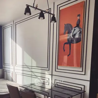 Elegant dining area with modern lighting and stylish artwork, perfect for sophisticated living.