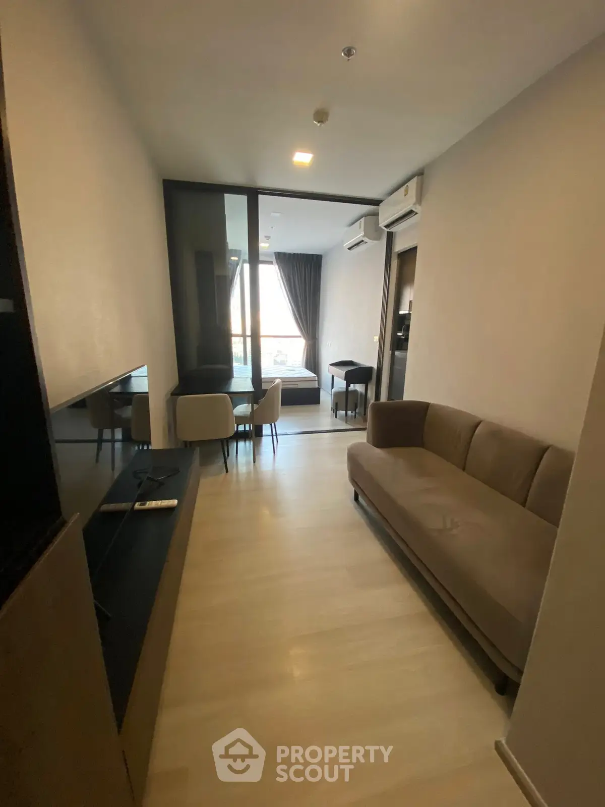 Modern living room with sleek furniture and dining area, featuring a cozy sofa and stylish decor.