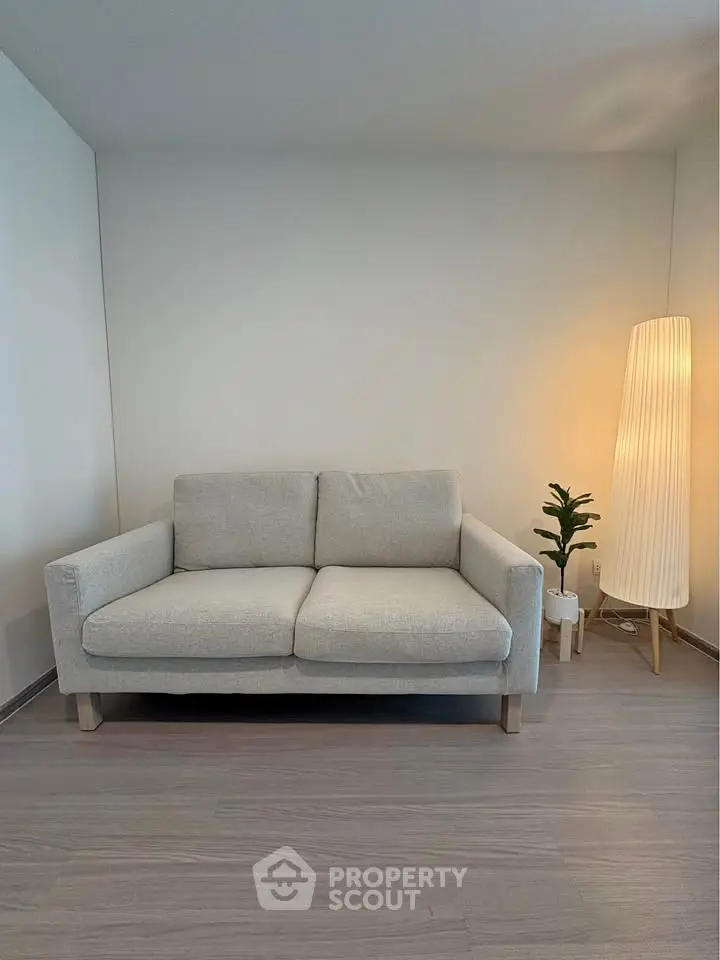 Modern minimalist living room with cozy sofa and stylish floor lamp.