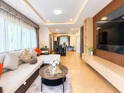 Spacious modern living room with elegant decor and large TV, perfect for relaxation and entertainment.