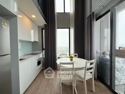 Modern kitchen with open layout and dining area, featuring high ceilings and large windows with city view.