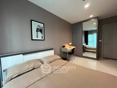Modern bedroom with stylish decor and large mirror reflecting natural light.
