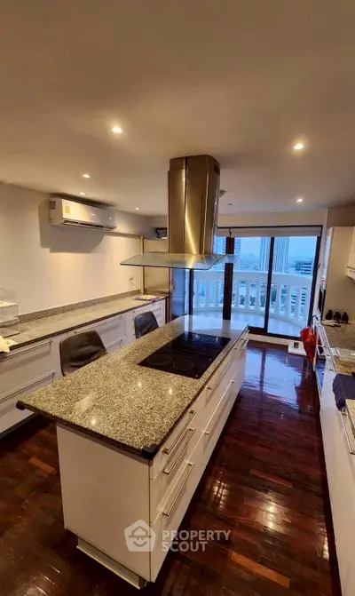 Spacious modern kitchen with island and open layout, featuring sleek design and city view.