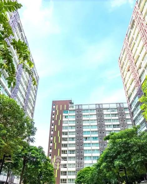 Modern high-rise residential buildings with lush greenery and clear blue sky.