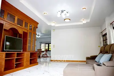 Spacious living room with elegant wooden cabinetry and modern lighting, perfect for family gatherings.