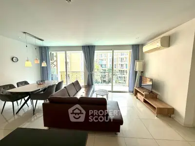 Spacious living room with modern furniture and large windows offering a bright ambiance.