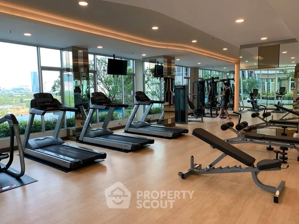 Spacious modern gym with state-of-the-art equipment and panoramic city views.