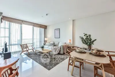 Spacious modern living room with elegant dining area and natural light.