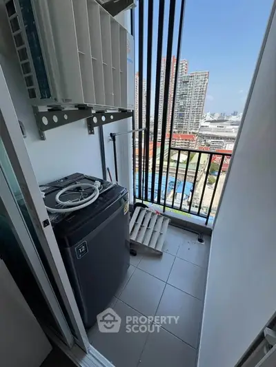 Compact balcony with washing machine and city view in modern apartment.