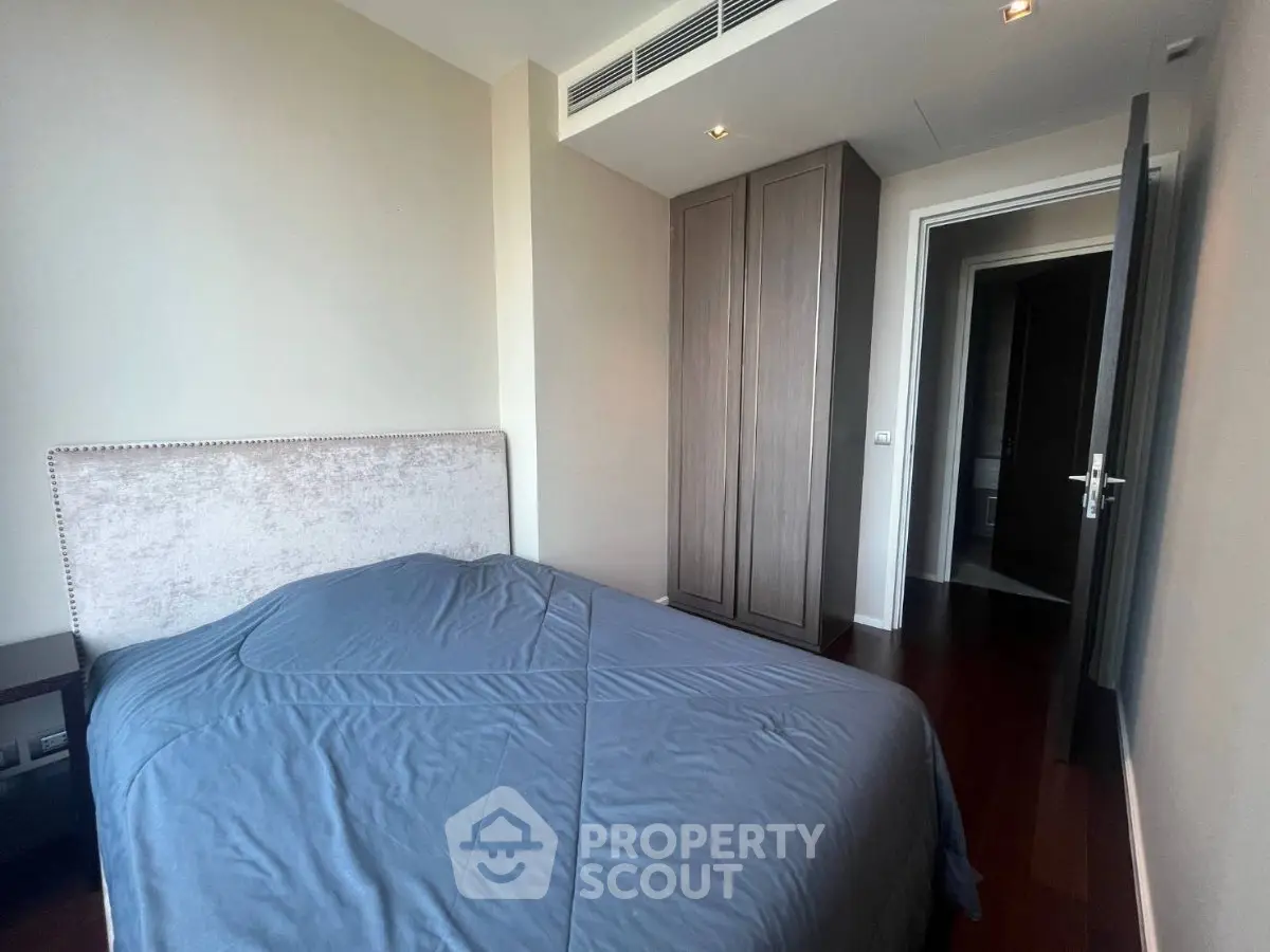 Cozy bedroom with elegant wooden flooring and modern wardrobe in a stylish apartment.