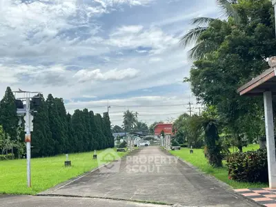 Charming driveway entrance with lush greenery and clear skies, perfect for serene living.