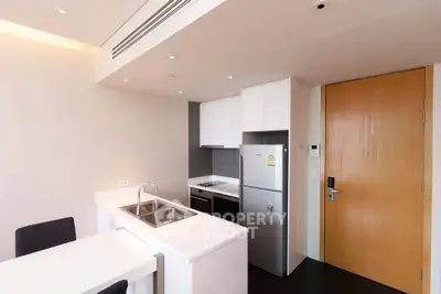 Modern kitchen with sleek design, featuring stainless steel appliances and minimalist white cabinetry.