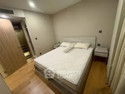 Cozy bedroom with wooden flooring and modern furniture, perfect for relaxation.