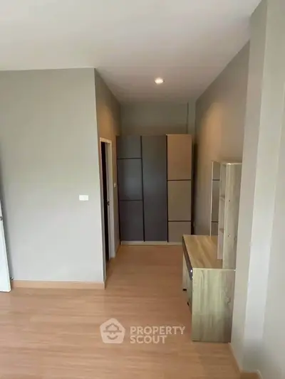 Modern minimalist bedroom with sleek wardrobe and wooden flooring