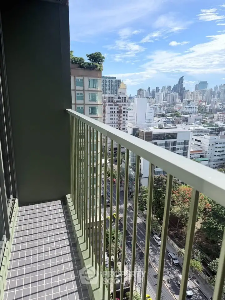 Stunning city view from a modern high-rise balcony with sleek railing.