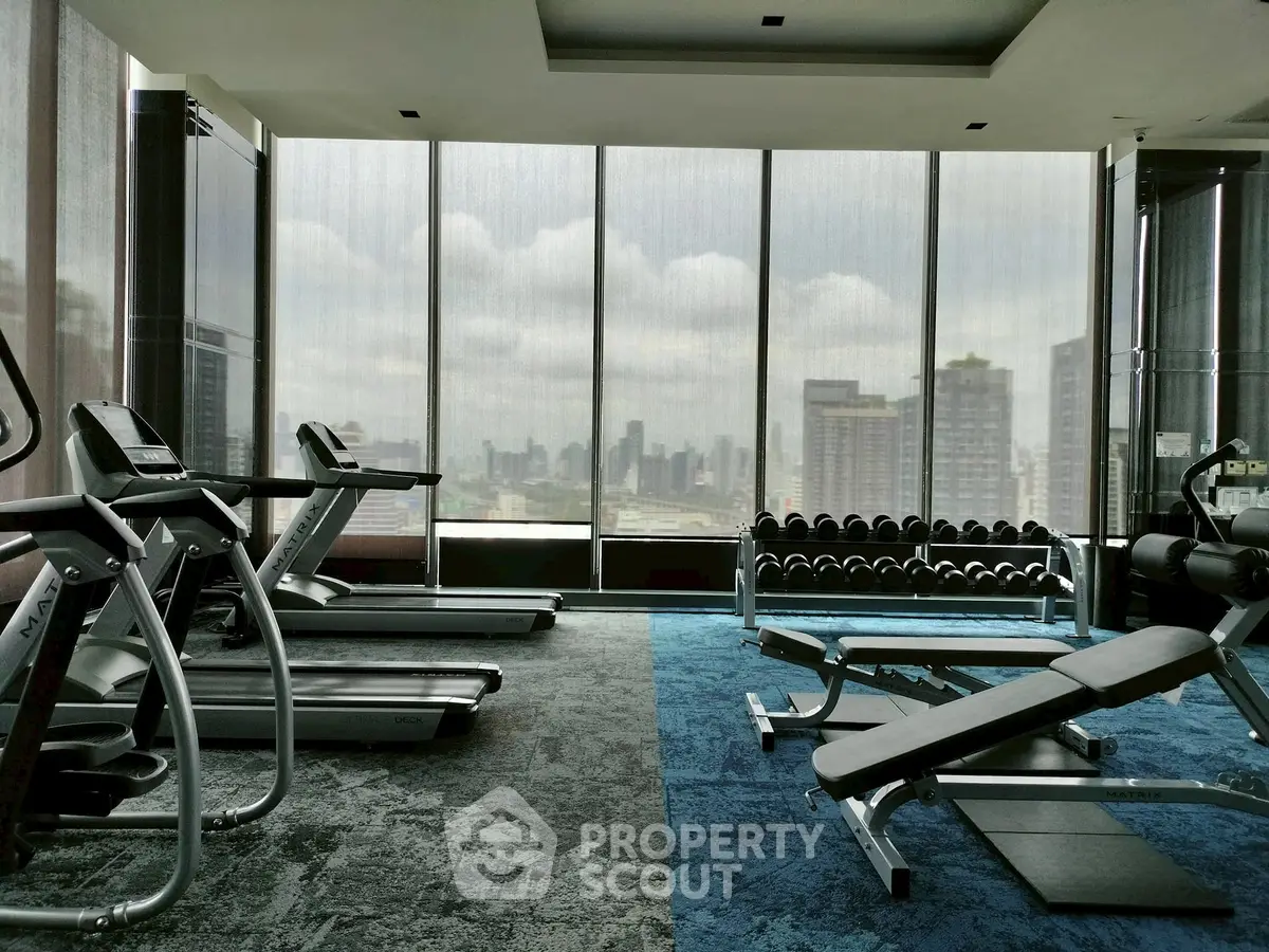 Luxurious high-rise gym with panoramic city views and modern fitness equipment.