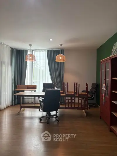 Spacious study room with elegant wooden flooring and modern furniture, perfect for productivity and comfort.