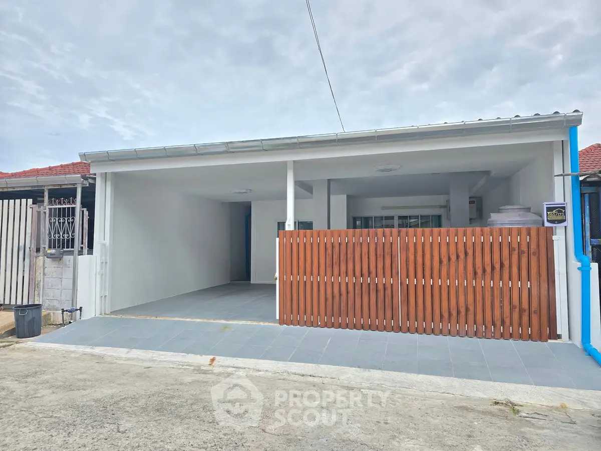 Modern single-story home with spacious carport and wooden fence in a quiet neighborhood.