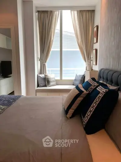 Cozy bedroom with elegant decor and large window seat, perfect for relaxation and natural light.