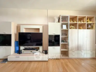 Spacious living room with modern entertainment center and wooden flooring