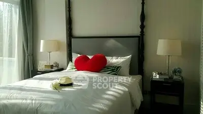 Charming bedroom with elegant decor and heart-shaped pillow, perfect for cozy living.