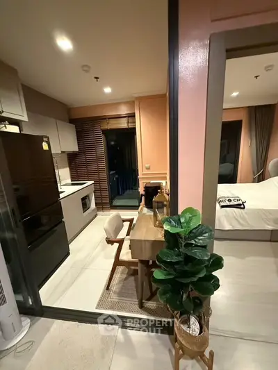 Modern open-layout kitchen and dining area with cozy bedroom view