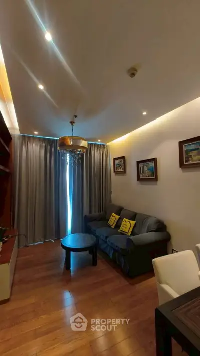 Cozy living room with elegant lighting and wooden flooring, featuring a comfortable sofa and stylish decor.