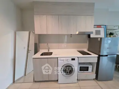 Modern kitchen with integrated appliances including washing machine and microwave, sleek cabinetry, and stylish design.