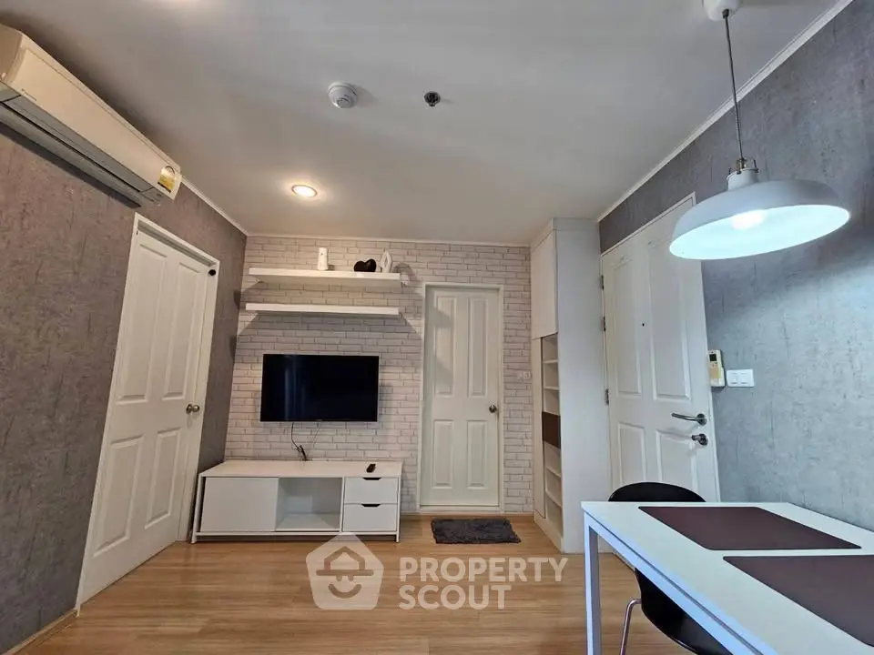 Modern living room with stylish decor and wall-mounted TV in a cozy apartment.