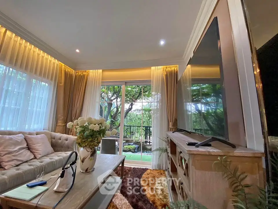 Luxurious living room with elegant decor and garden view, featuring plush seating and modern entertainment setup.