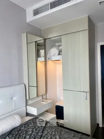 Modern bedroom with sleek wardrobe and cozy bed in stylish apartment.