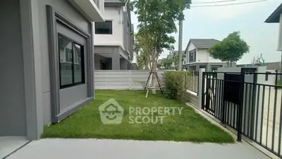 Modern townhouse with lush green lawn and secure gated entrance