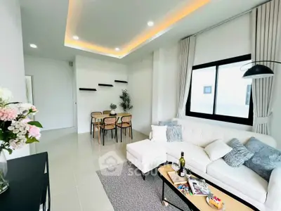 Modern living room with elegant decor and dining area, featuring cozy seating and stylish lighting.