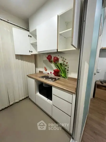 Modern kitchen with open cabinets and floral backsplash in compact apartment