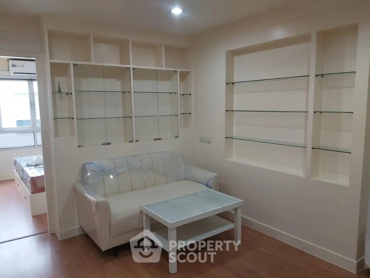 Modern living room with built-in glass shelves and cozy white sofa