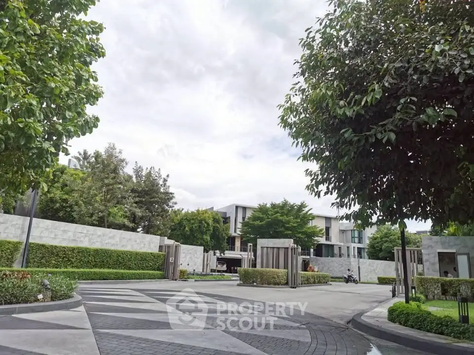 Luxurious modern residential entrance with lush greenery and elegant design.